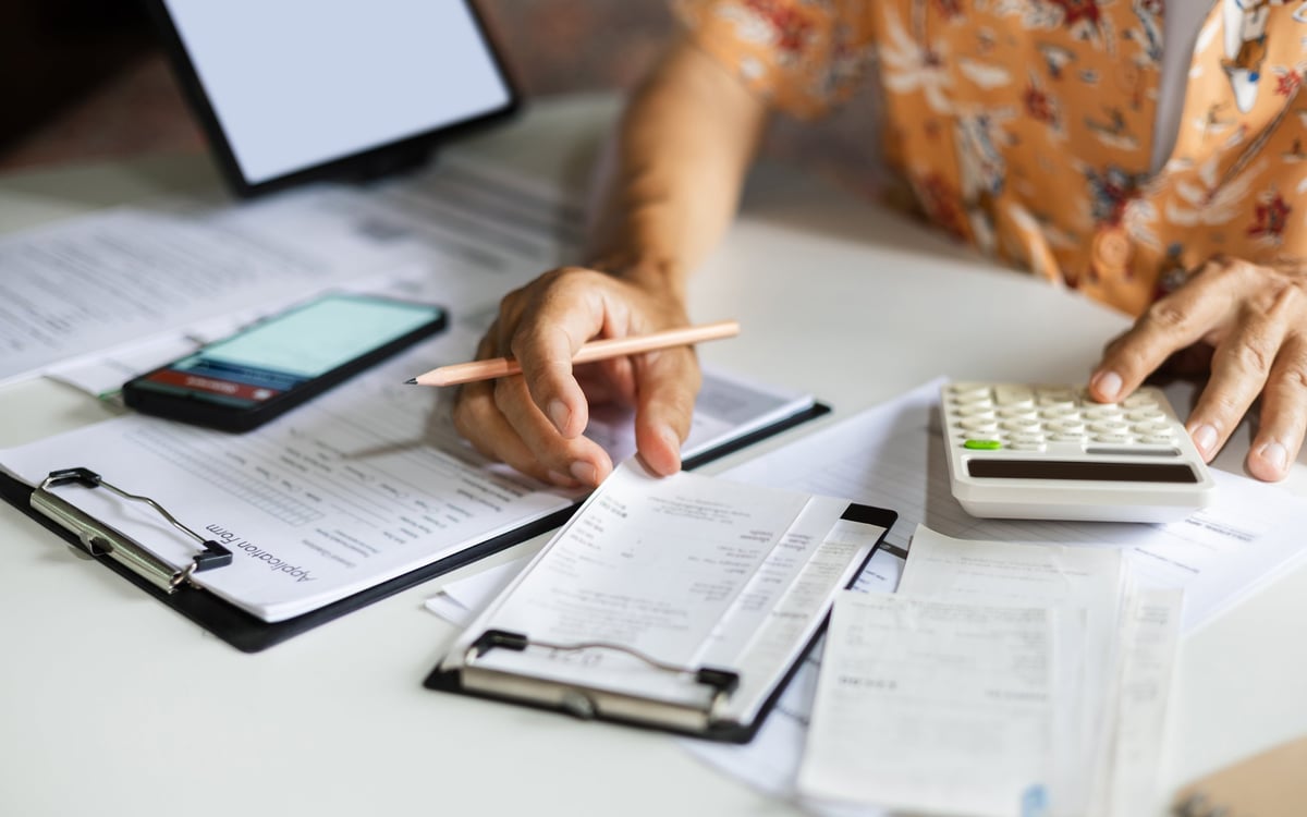 A man working from home checking receipts and calculating expenses